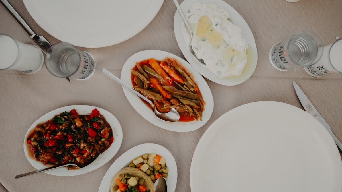 Top view of various delicious food on table with dishware and silverware in restaurant on daytime